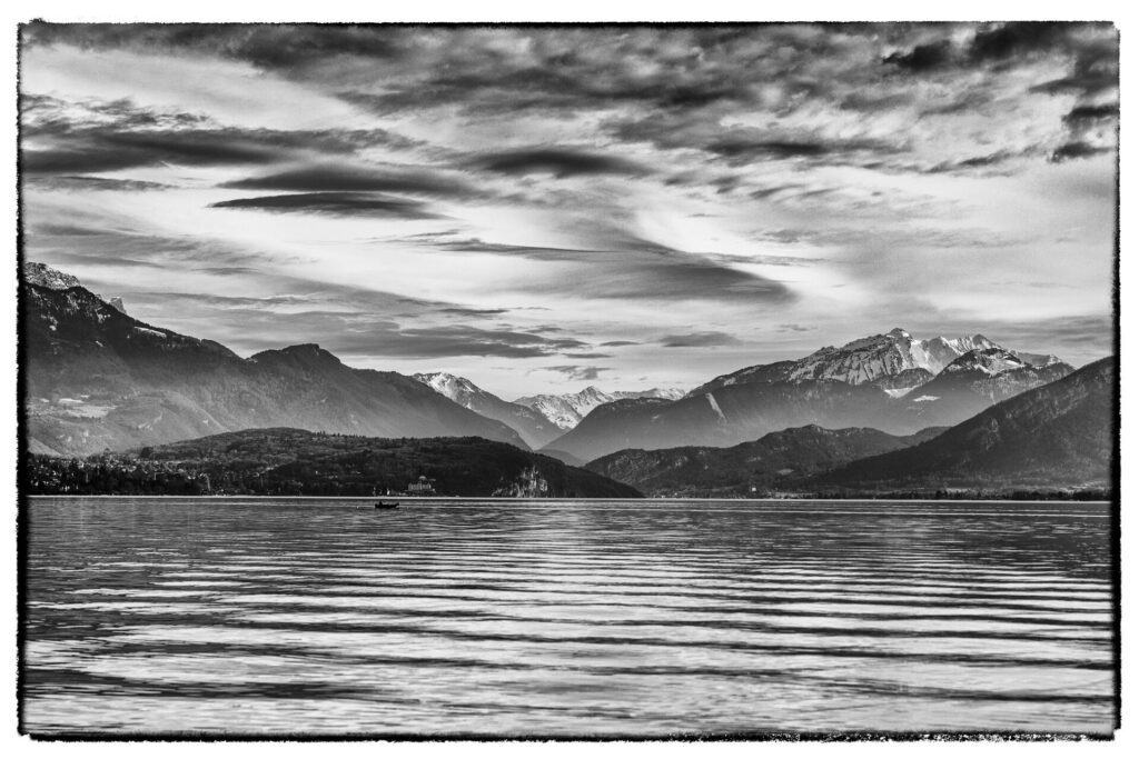 Photo noir et blanc des montagnes au bout du lac d'Annecy