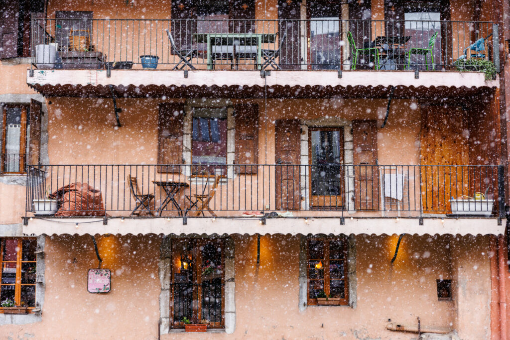 Façade d'un immeuble annécien derrière les flocons