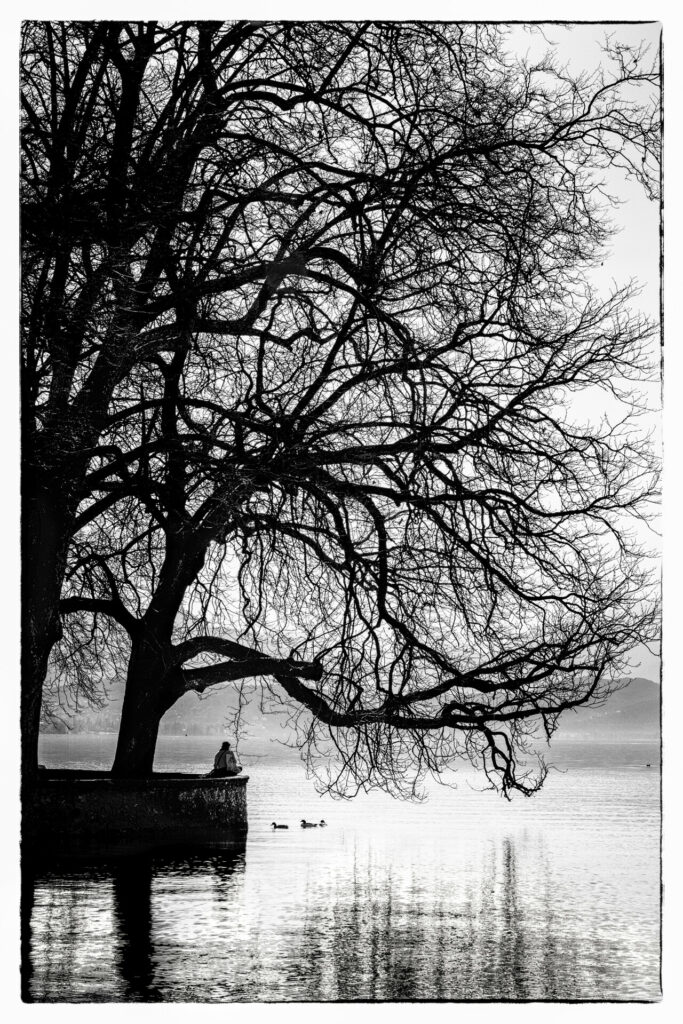 Photographie artistique d'une femme contemplant le lac d'Annecy