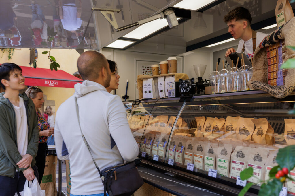 Touristes en discussion avec le marchand de café au marché de la vieille ville à Annecy