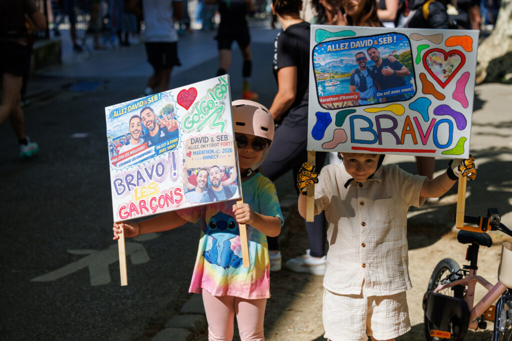 2 enfants avec des pancartes de soutien au marathon d’Annecy 2026