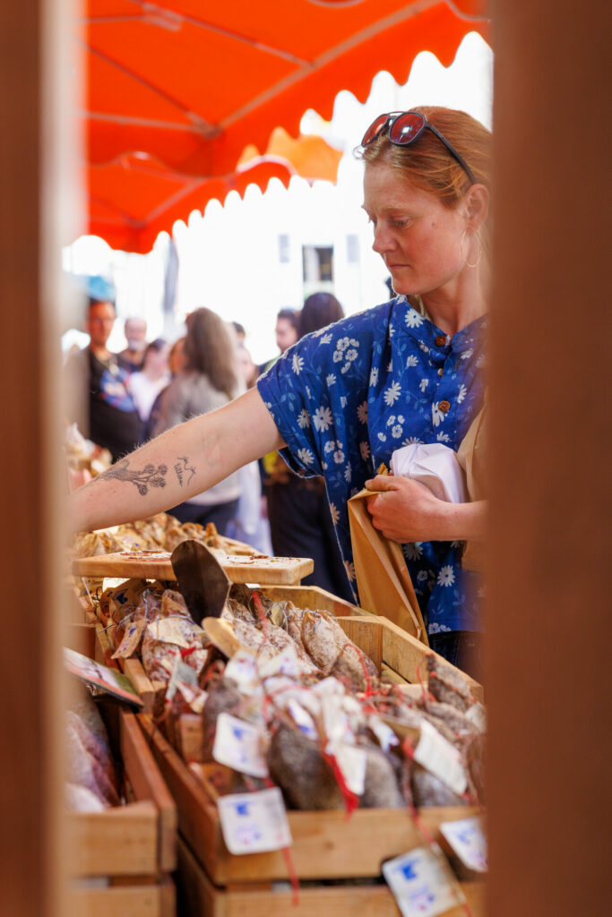 Cliente achetant de la charcuterie au marché de la vieille ville à Annecy