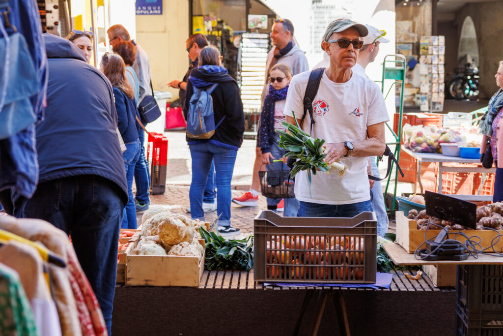Client achetant des poireaux au marché de la vieille ville à Annecy