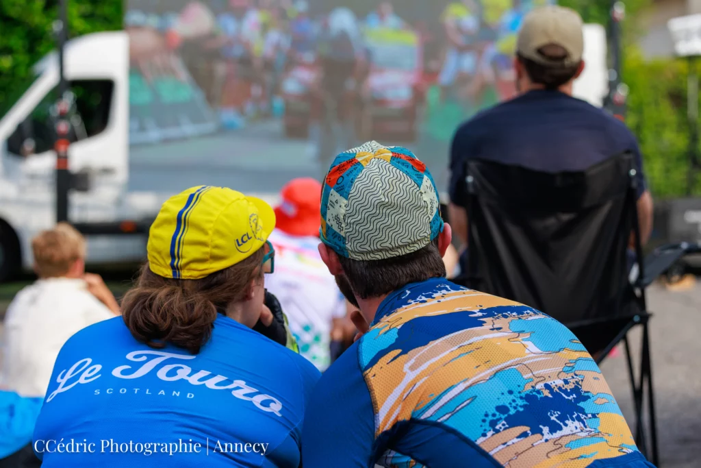 Un couple regarde l'écran géant qui montre le Tour de France
