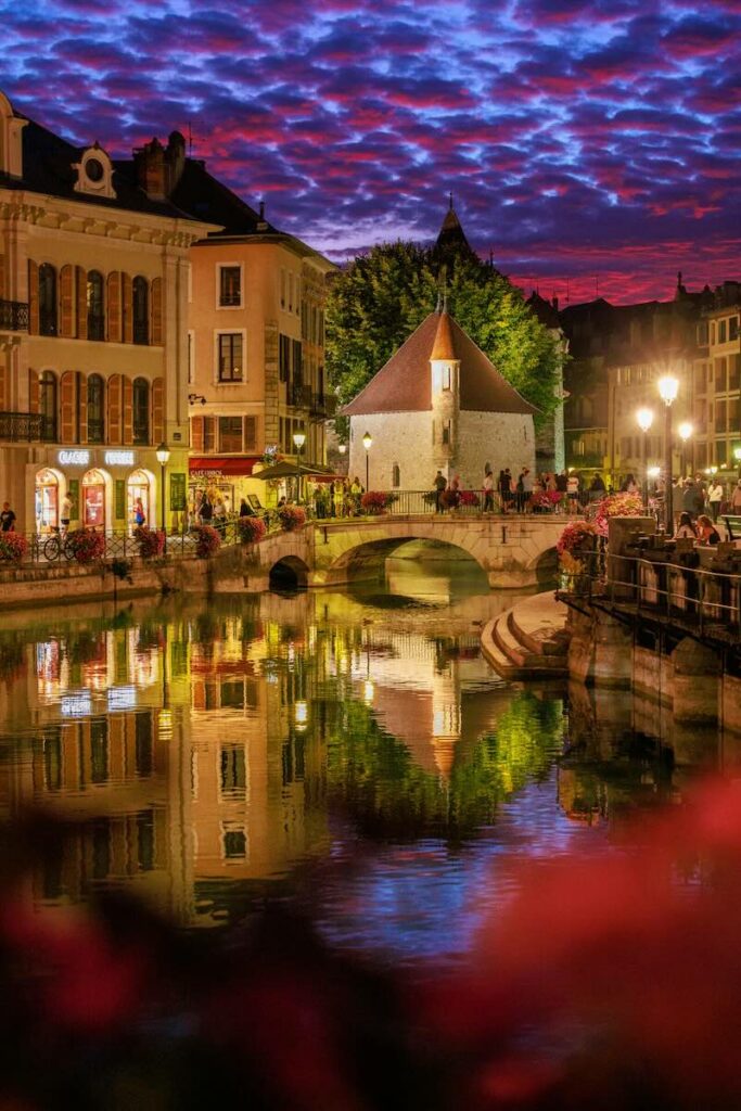 Le Palais de l'Île à Annecy et son reflet dans le Thiou au coucher du soleil.