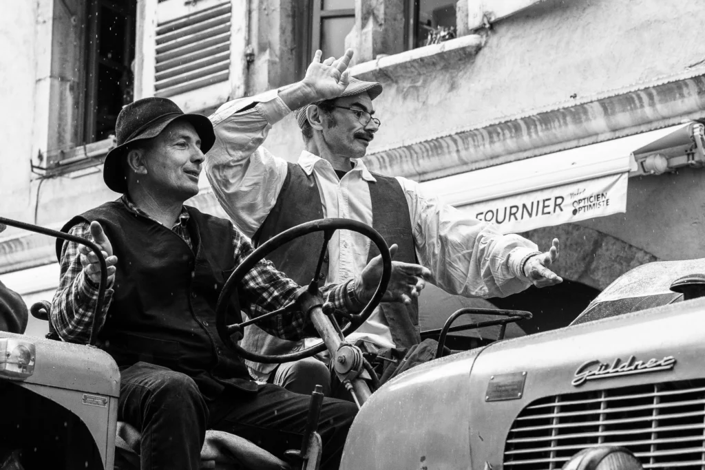 Agriculteurs en costume traditionnel sur leur tracteur lors du défilé du Retour des Alpages à Annecy