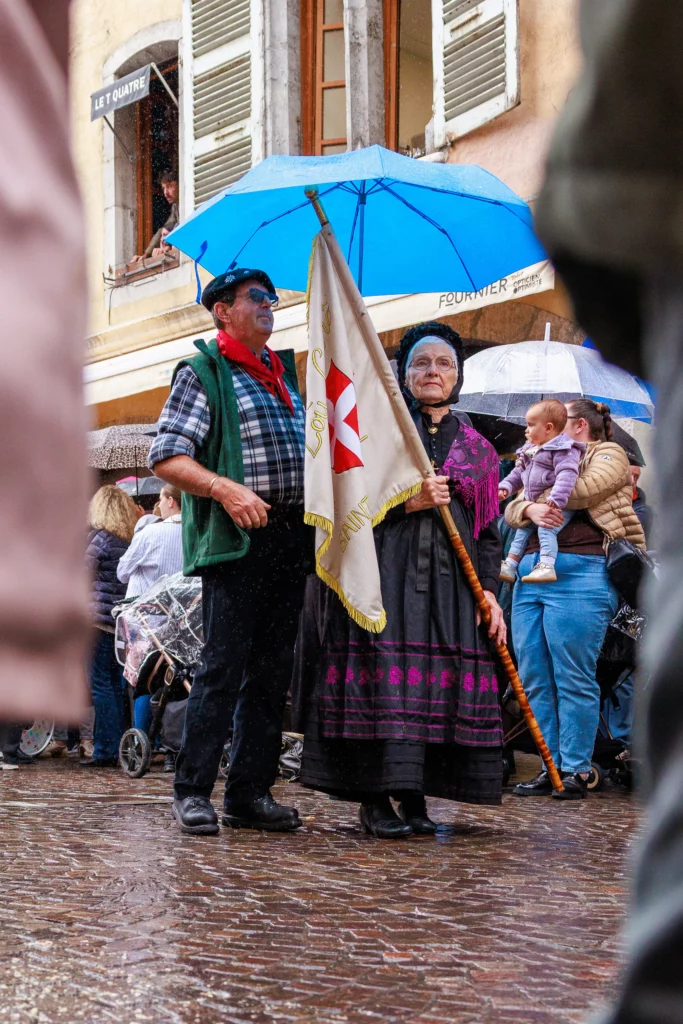 Couple en costume traditionnel lors du défilé tenant un drapeau savoyard