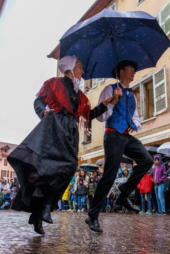 Danseurs traditionnels sous la pluie lors du Retour des Alpages à Annecy
