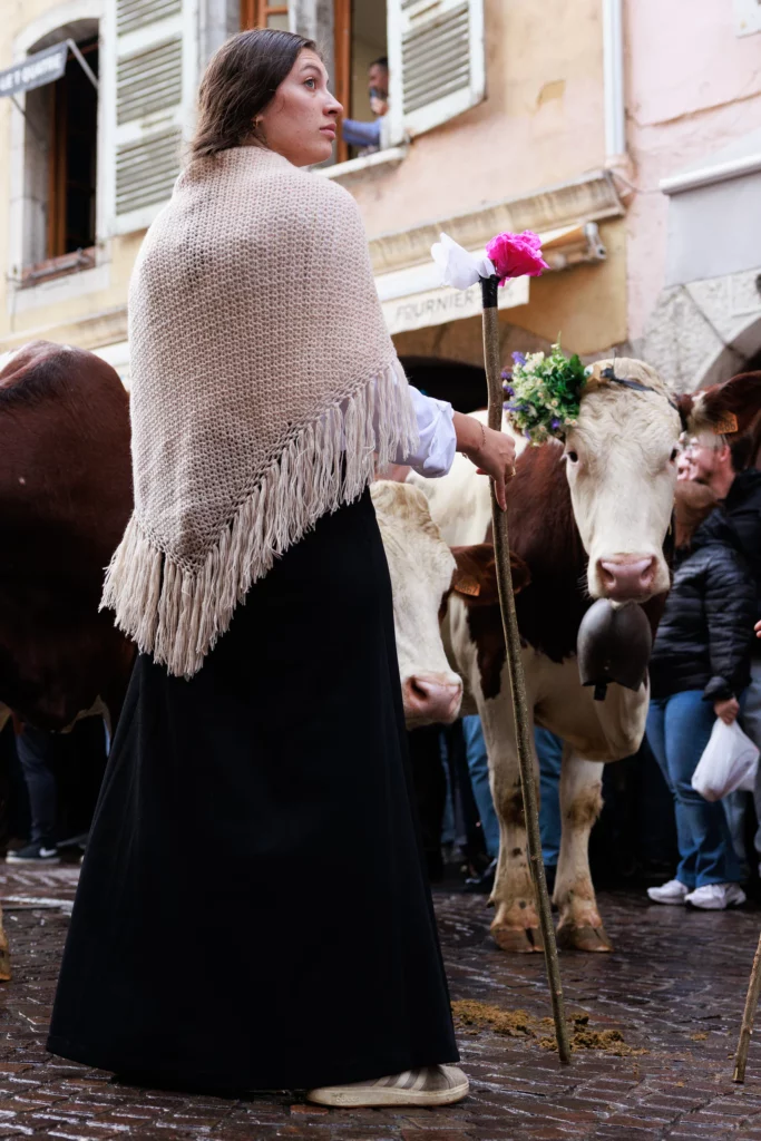 Jeune agricultrice qui garde les vaches dans la vieille ville d'Annecy